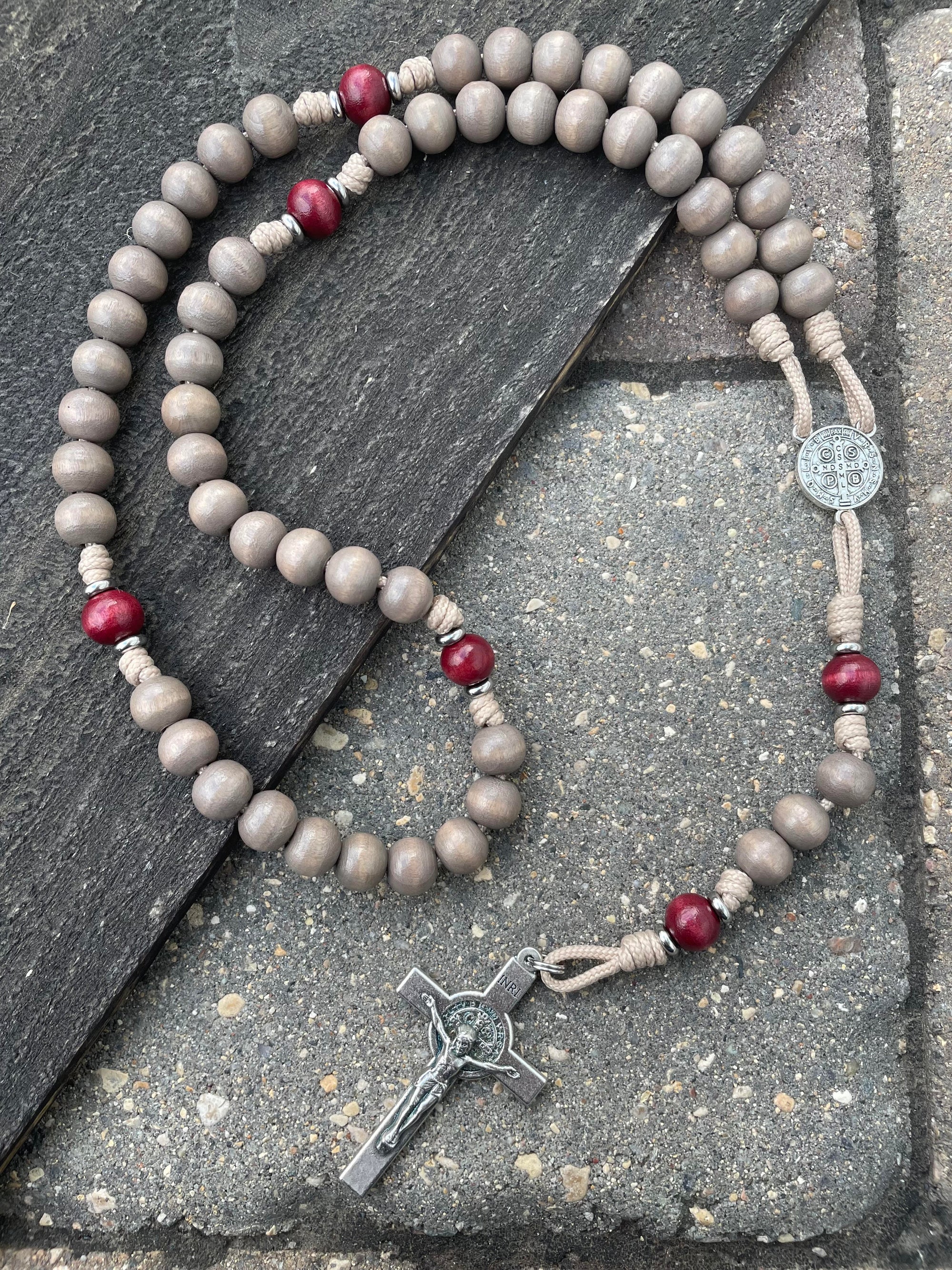 Bethlehem Christmas rosary with light gray and red wooden beads, oxidized silver St. Benedict crucifix, and paracord