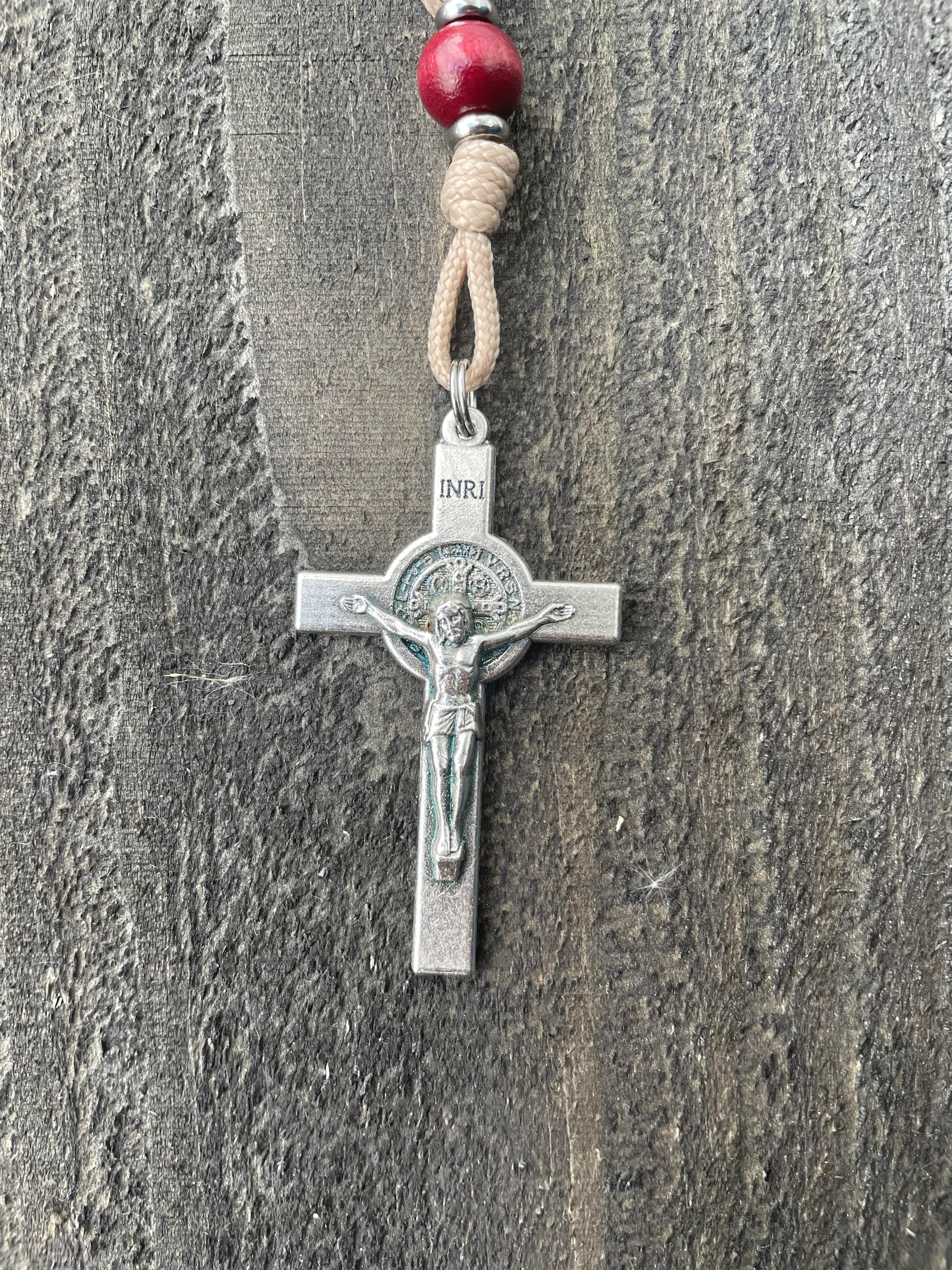 Close-up of oxidized silver medal and paracord detail on handcrafted wooden christmas rosary