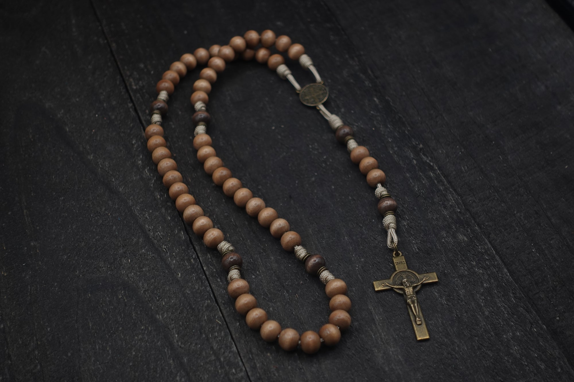 paracord rosary with tan and gray-brown wooden beads with bronze St. Benedict crucifix and medal