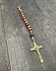 Close-up of a rosary with sand-colored beads, durable knots, and a detailed silver crucifix, displayed on a light wooden surface, ideal for prayer and meditation.