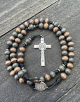 Durable black paracord rosary featuring gray-brown stained wooden beads and silver crucifix centerpiece