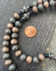 Detailed view of hand-stained wooden beads on black paracord rosary built for daily devotion