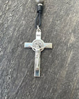 Close-up of silver St. Benedict crucifix on rosary with gray and charcoal wood beads