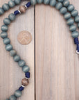 Detailed view of exclusive gray-blue stained wood beads with natural variations on durable paracord rosary