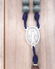 Miraculous Medal centerpiece detail on King of Glory rosary with silver hardware and gray-blue beads