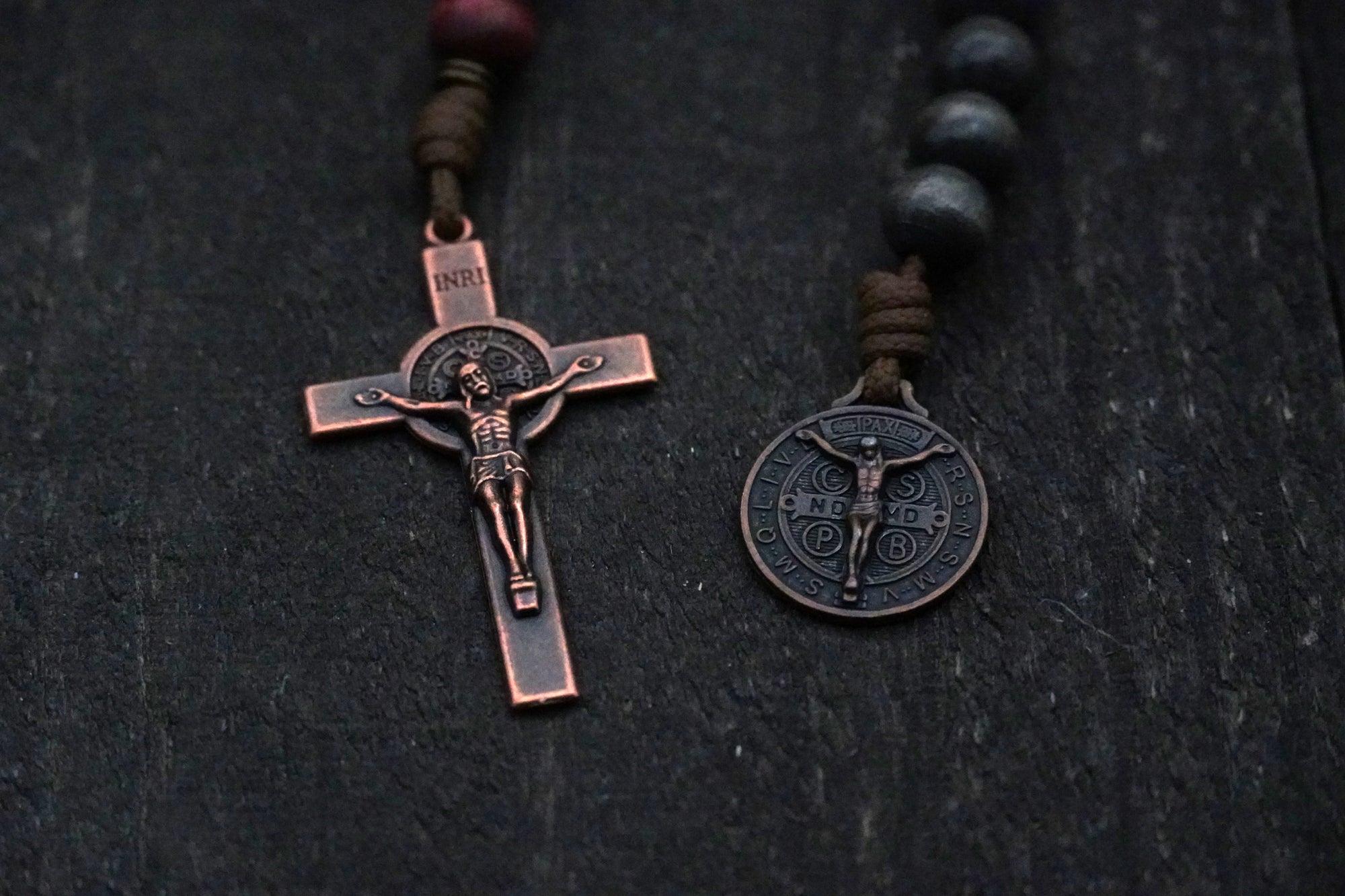 Close-up of bronze Pardon Crucifix and Miraculous Medal on handcrafted paracord rosary