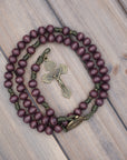 Handcrafted rosary featuring burgundy wood beads with bronze crucifix and Miraculous Medal centerpiece