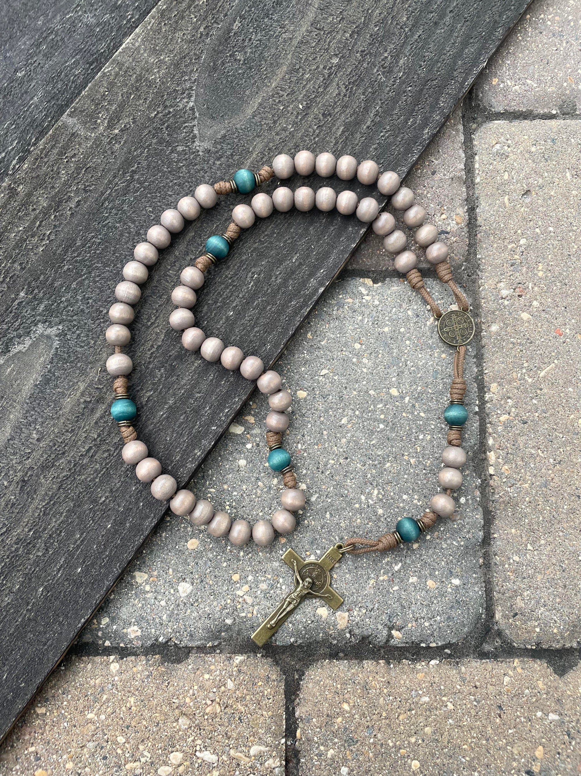 Noel Christmas rosary with teal and gray wooden beads, bronze St. Benedict crucifix, and durable paracord
