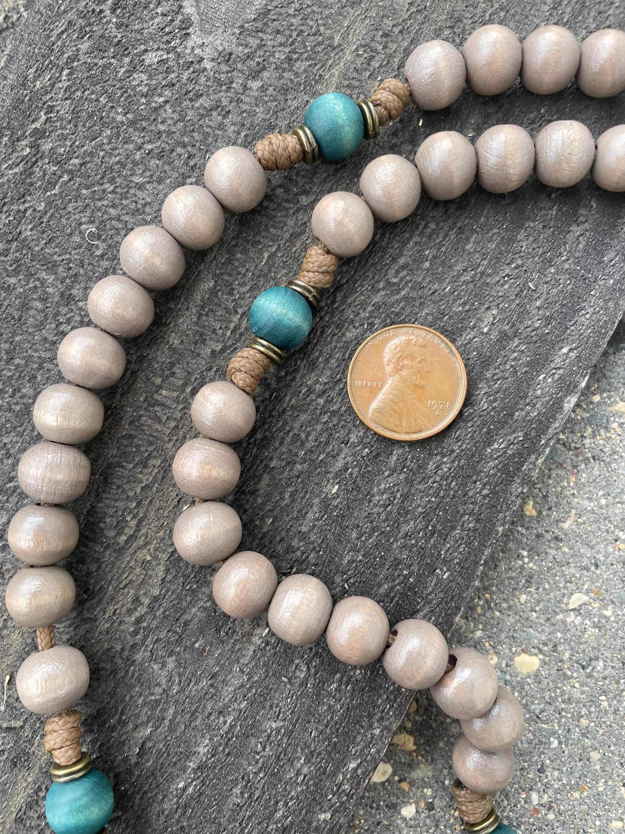 Handmade Christmas rosary featuring teal and gray wood beads with bronze crucifix and medal centerpiece