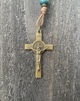 Close-up of bronze St. Benedict crucifix on Noel Christmas rosary with teal and gray beads