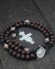 Padre Pio rosary by Runewood Rosary combining walnut wood beads, silver crucifix, and black paracord for faithful devotion