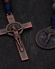 Close-up of copper St. Benedict crucifix on Pocket Sword of the Spirit rosary with navy paracord