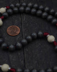 Close-up of charcoal and vintage white wooden beads on Pope Leo XIV rosary showing heirloom craftsmanship