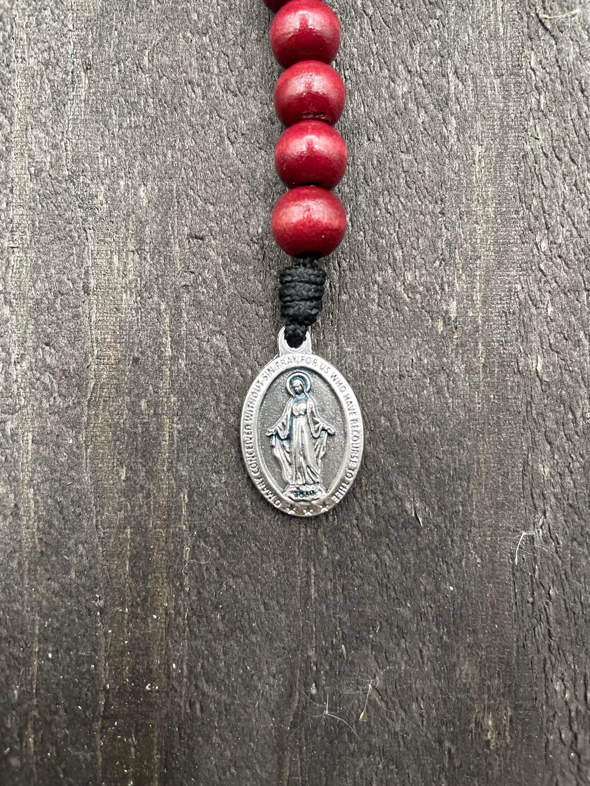 Full view of a rosary with vibrant red beads, durable red knot accents, and a detailed crucifix pendant, designed for prayer and spiritual devotion.