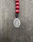 Full view of a rosary with vibrant red beads, durable red knot accents, and a detailed crucifix pendant, designed for prayer and spiritual devotion.