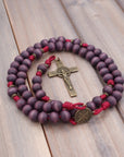 Handcrafted rosary featuring exclusive purple wood beads with bronze crucifix and St. Benedict medal centerpiece