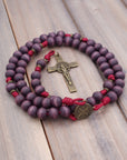 Close-up of bronze St. Benedict crucifix on Roma Victor rosary with purple wood beads
