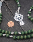 Handcrafted women’s rosary featuring green wood beads, silver crucifix, and St. Dymphna medal centerpiece