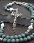 St. Maria Goretti womens rosary with faded blue and white wooden beads, silver St. Benedict crucifix, and silver paracord