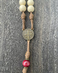 Bronze St. Benedict medal centerpiece on St. Nicholas Christmas rosary with red and white beads