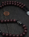 Handcrafted Catholic men’s rosary featuring dark wood beads, silver crucifix, and Miraculous Medal centerpiece