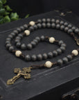 Handcrafted rosary honoring Pope Leo XIV featuring charcoal wood beads, bronze crucifix, and Miraculous Medal centerpiece