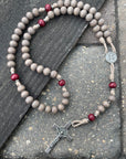 Bethlehem Christmas rosary with light gray and red wooden beads, oxidized silver St. Benedict crucifix, and paracord
