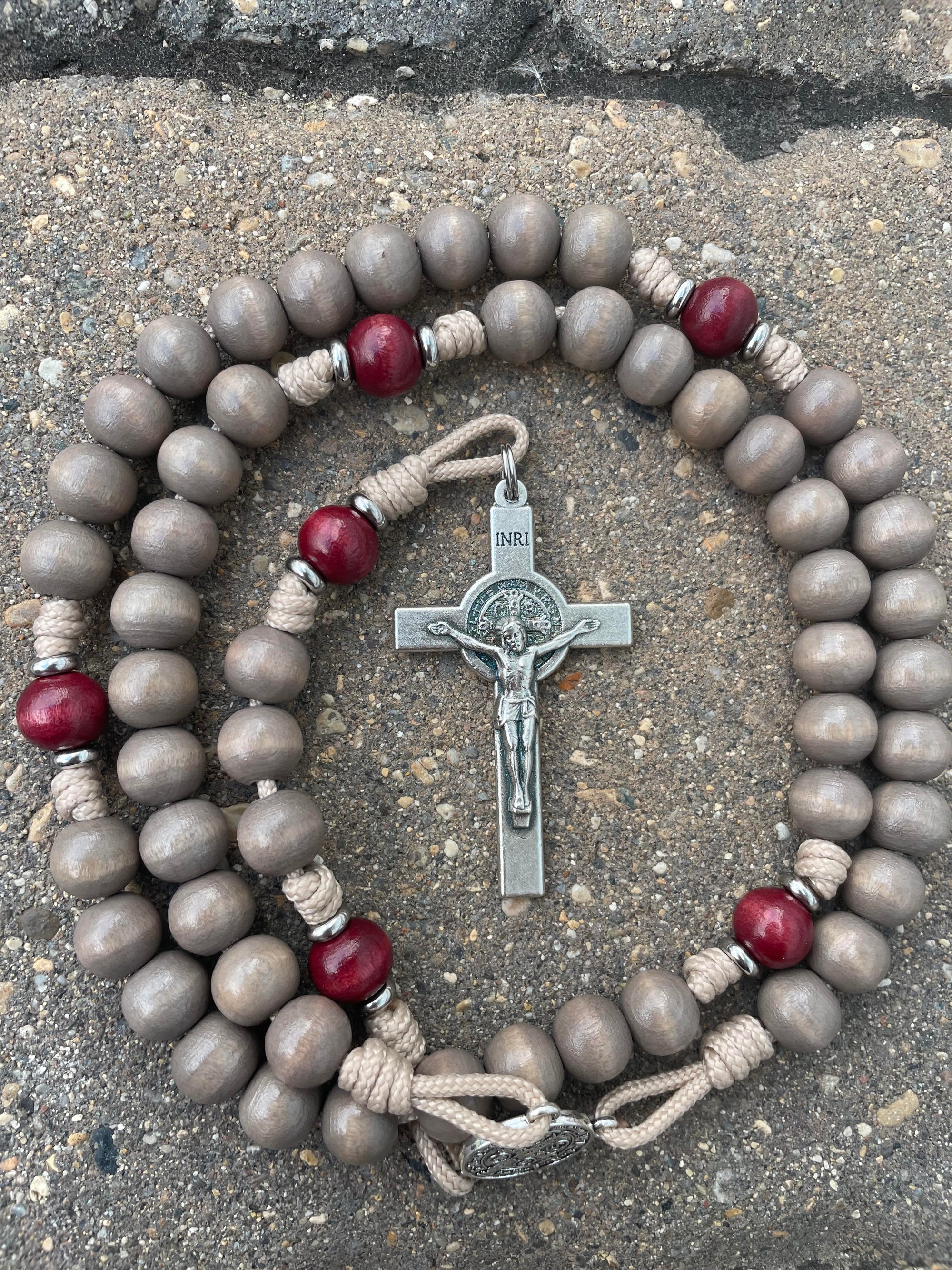 Handcrafted paracord christmas rosary featuring red and gray wood beads with silver crucifix and medal centerpiece