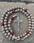 Handcrafted paracord christmas rosary featuring red and gray wood beads with silver crucifix and medal centerpiece