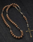 paracord rosary with tan and gray-brown wooden beads with bronze St. Benedict crucifix and medal
