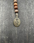 Handmade pocket paracord rosary featuring stained brown wood beads and bronze hardware