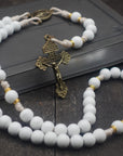 Heavenly Grace rosary with white wooden beads, gold spacers, bronze Pardon crucifix, and cream paracord