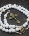 Heavenly Grace rosary for wedding and first communion gifts with white wooden beads, gold spacers, bronze Pardon crucifix, and cream paracord