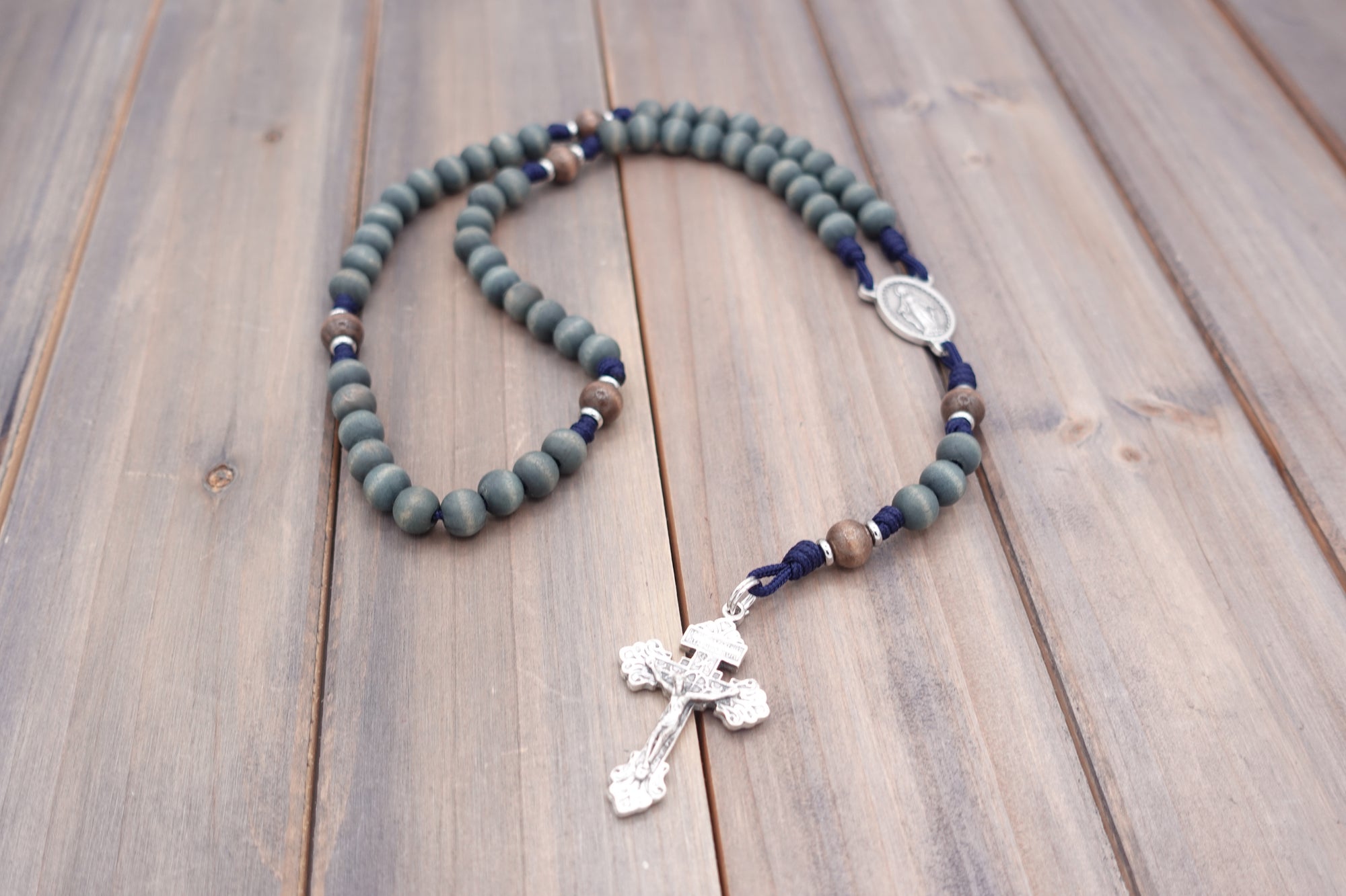 Handcrafted rosary featuring gray-blue and gray wood beads with silver crucifix and Miraculous Medal centerpiece