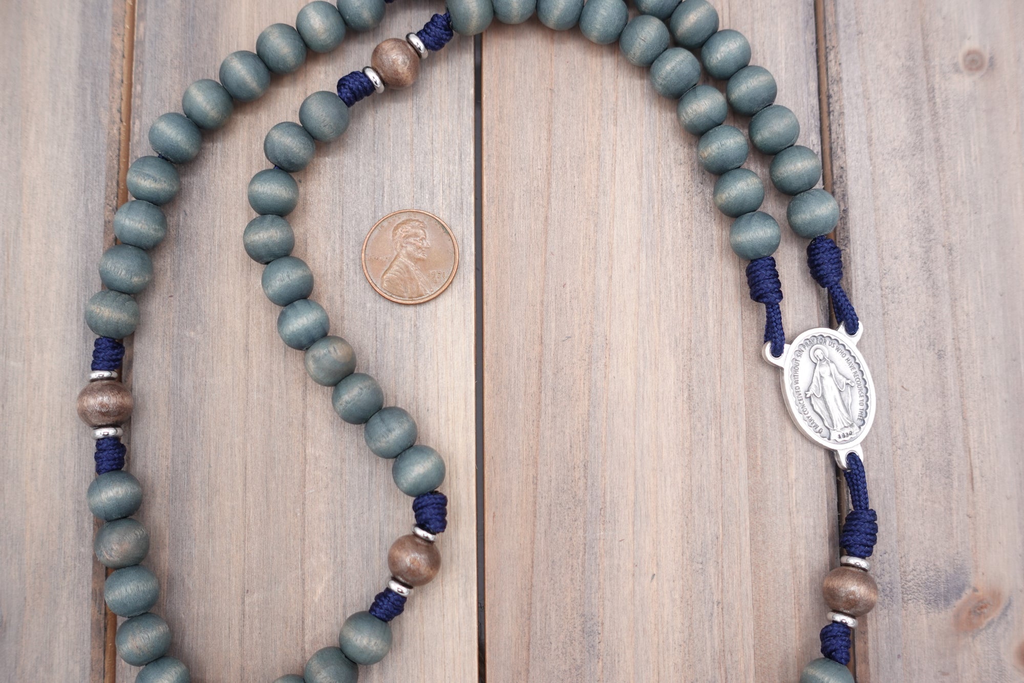 Detailed view of exclusive gray-blue stained wood beads with natural variations on durable paracord rosary