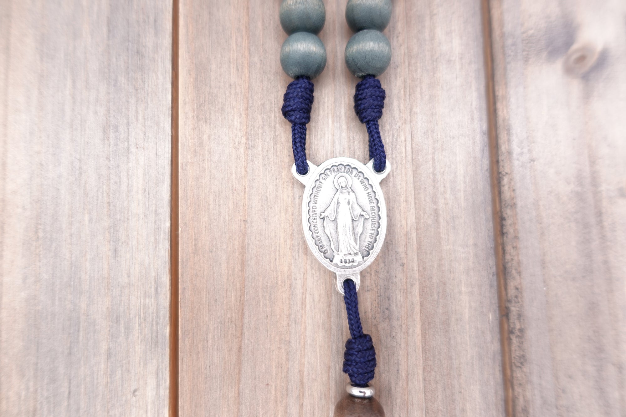 Miraculous Medal centerpiece detail on King of Glory rosary with silver hardware and gray-blue beads