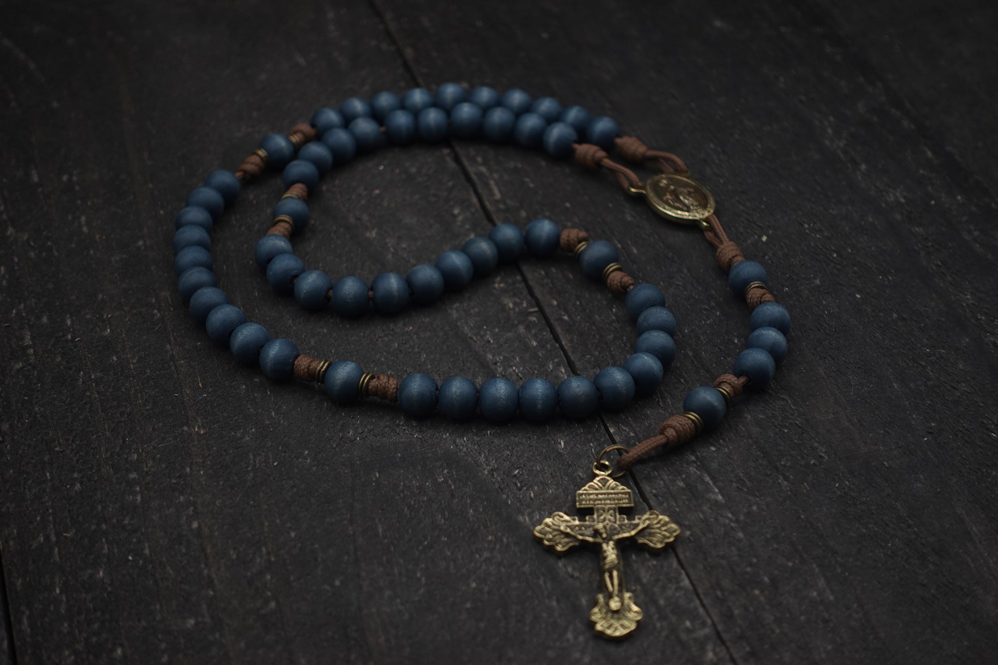 Durable paracord rosary built for daily prayer with bronze hardware and blue stained wooden beads
