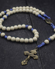 Handcrafted womens rosary featuring white wood beads, bronze crucifix, and spacer beads on lavender paracord