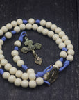 Close-up of bronze Pardon crucifix on Marian Devotion womens rosary with vintage white wooden beads