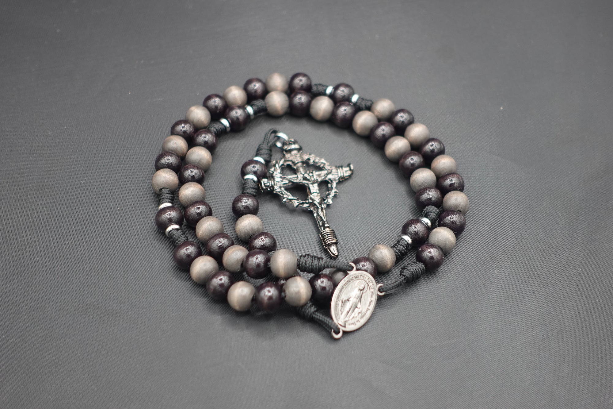 Memento Mori rosary with gray-brown and charcoal wooden beads, silver Crown of Thorns crucifix, and black paracord