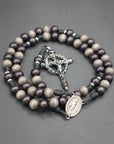Memento Mori rosary with gray-brown and charcoal wooden beads, silver Crown of Thorns crucifix, and black paracord