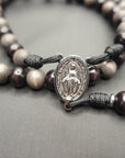 Miraculous Medal centerpiece detail on Memento Mori rosary with silver hardware and wooden beads