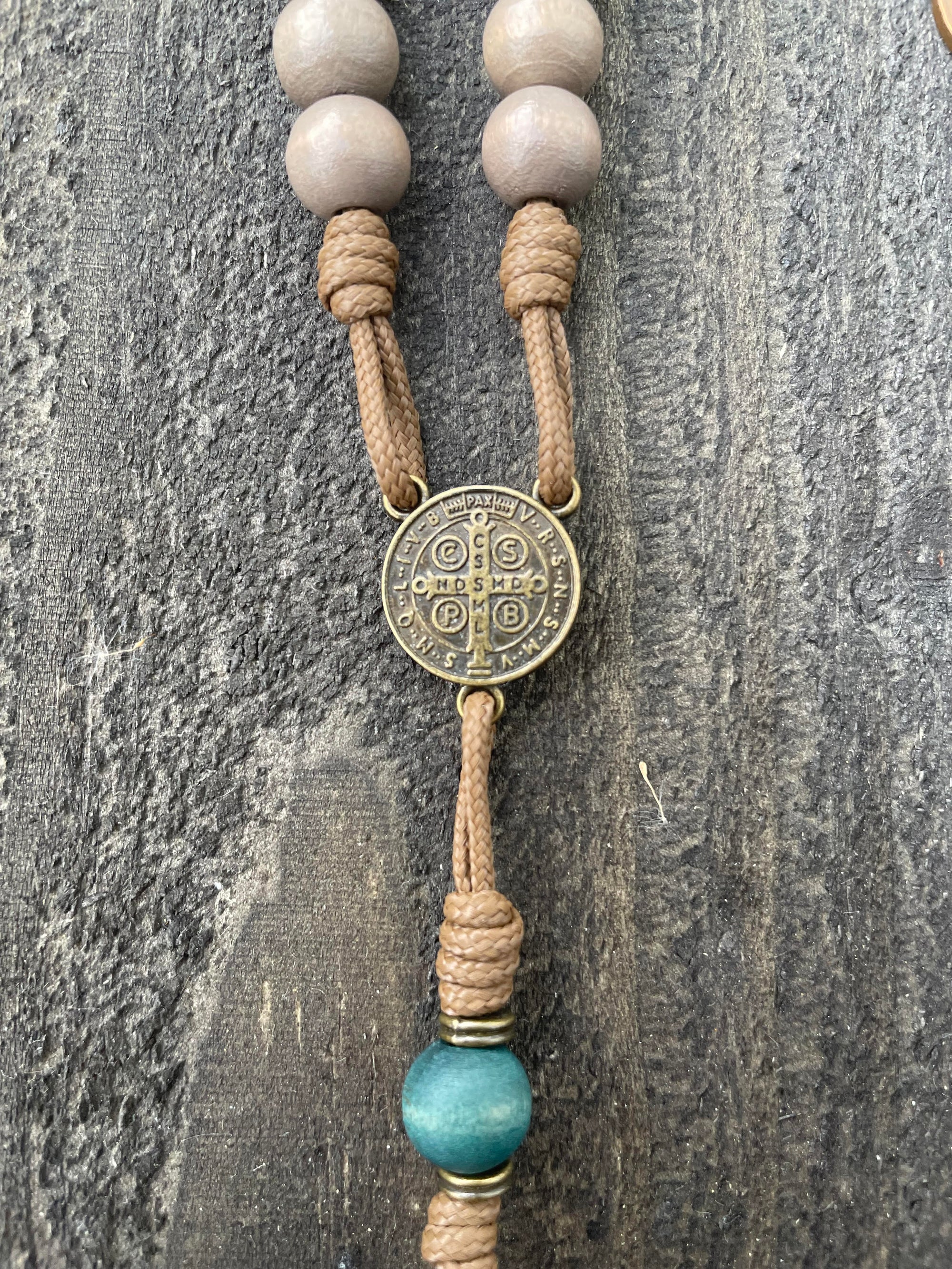 Close-up of bronze medal and paracord craftsmanship on handcrafted Noel Christmas rosary