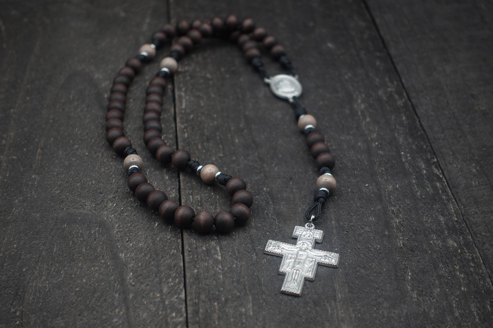 Handcrafted padre pio rosary featuring walnut-stained Hail Mary beads, gray Our Father beads, and Padre Pio medal centerpiece