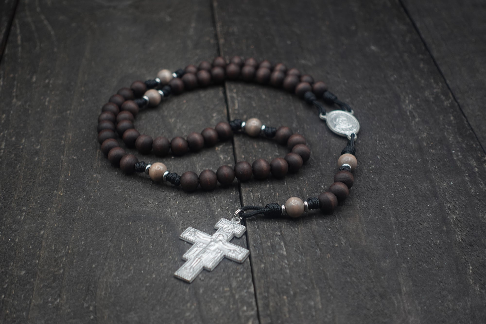 Padre Pio rosary by Runewood Rosary combining walnut wood beads, silver crucifix, and black paracord for faithful devotion