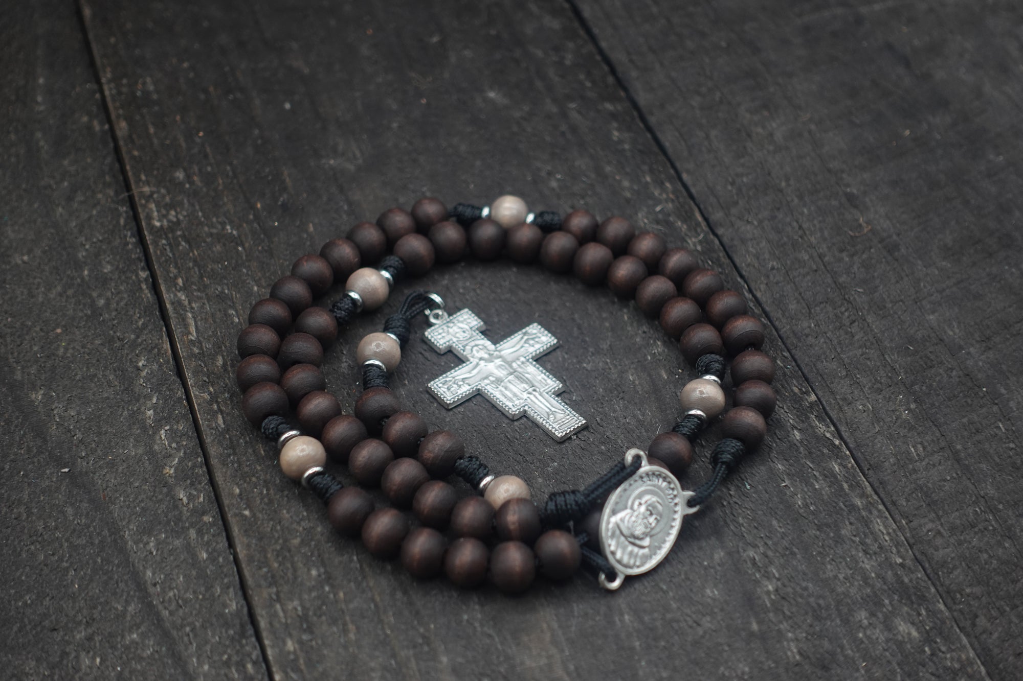Padre Pio rosary by Runewood Rosary combining walnut wood beads, silver crucifix, and black paracord for faithful devotion