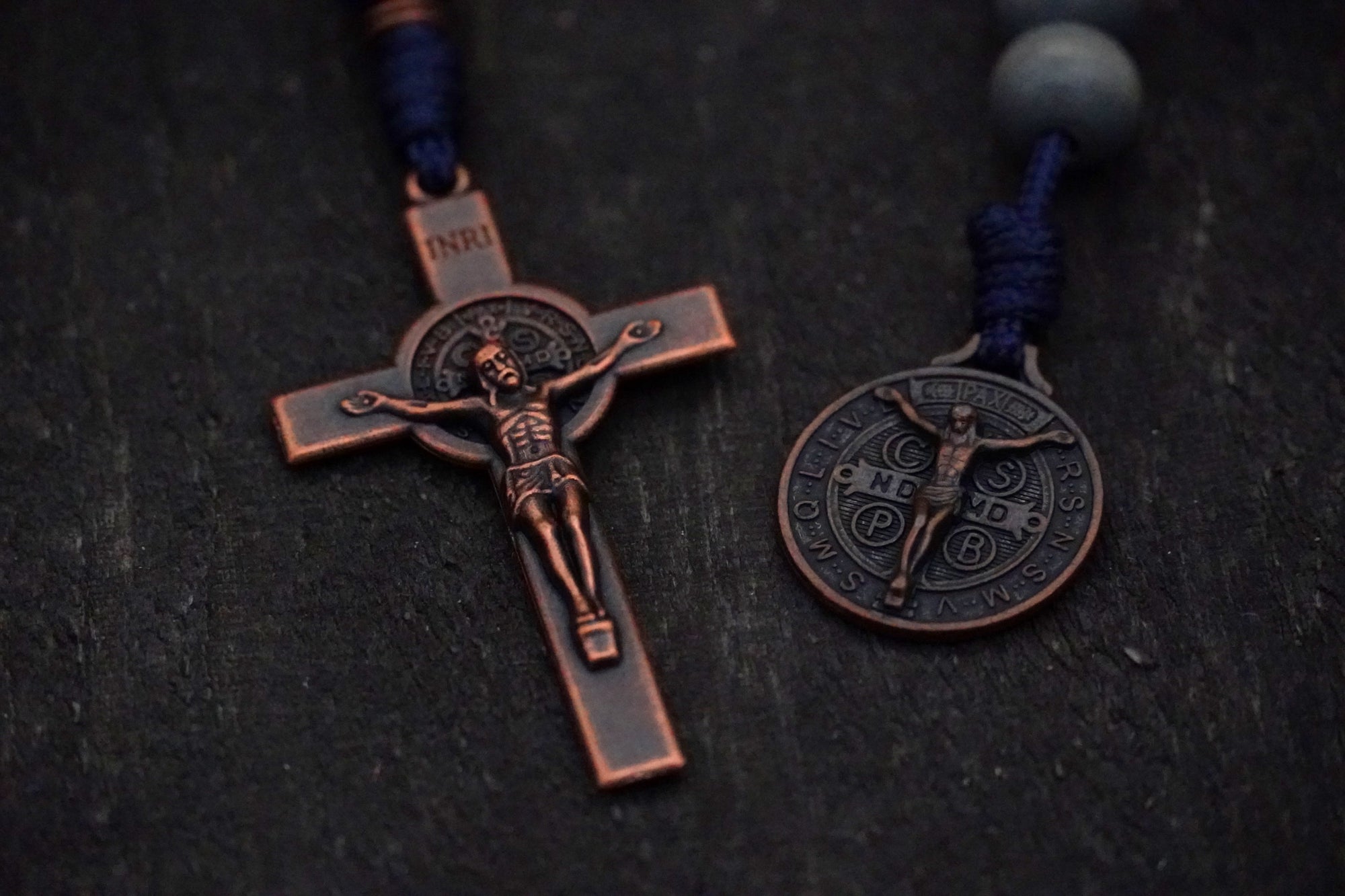 Close-up of copper St. Benedict crucifix on Pocket Sword of the Spirit rosary with navy paracord
