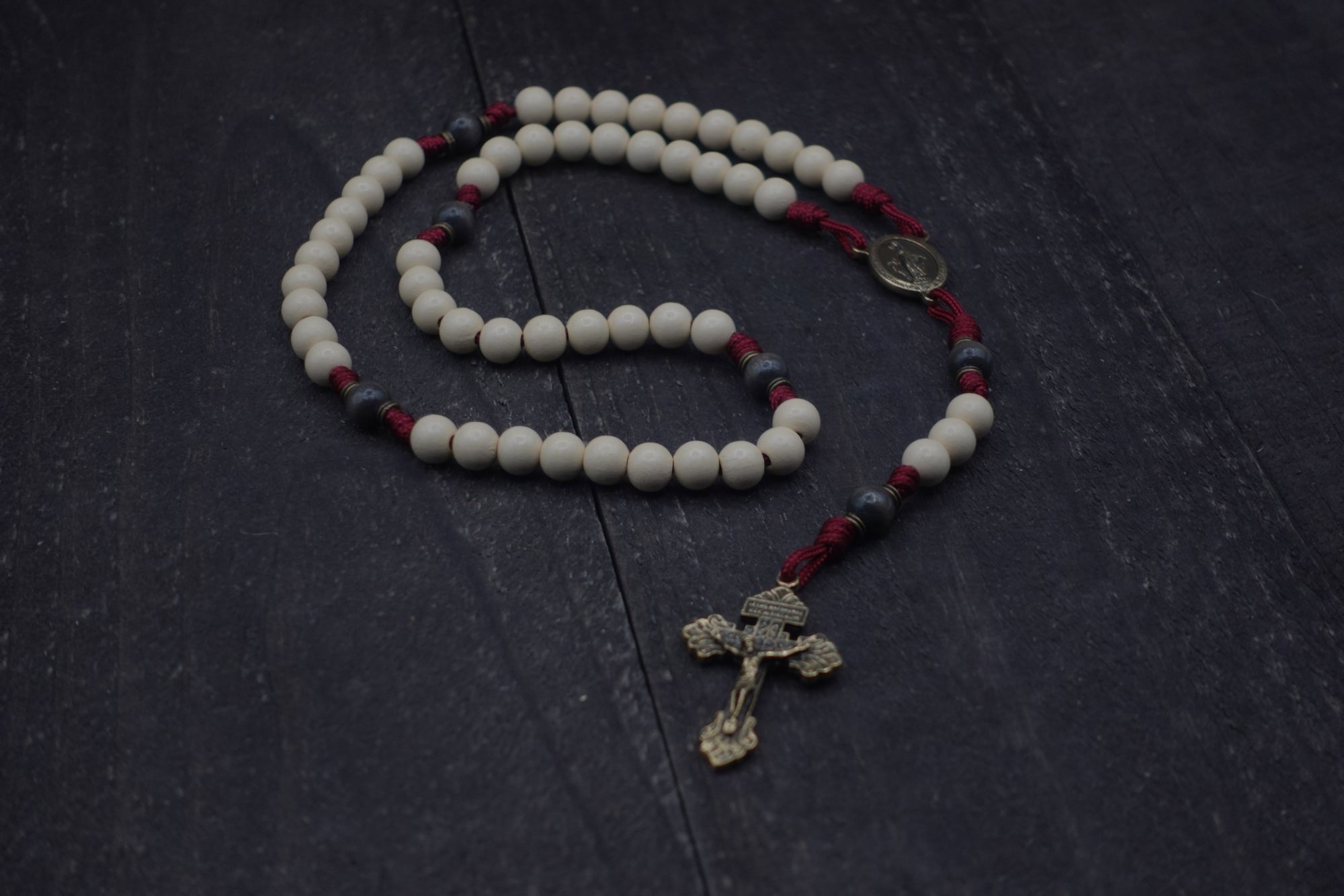 Handcrafted rosary inspired by Pope Leo XIV featuring white and charcoal wood beads with bronze crucifix and medal centerpiece