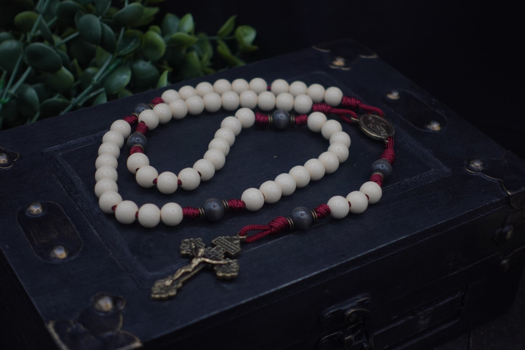 Close-up of vintage white and charcoal wooden beads on Pope Leo XIV rosary showing heirloom craftsmanship