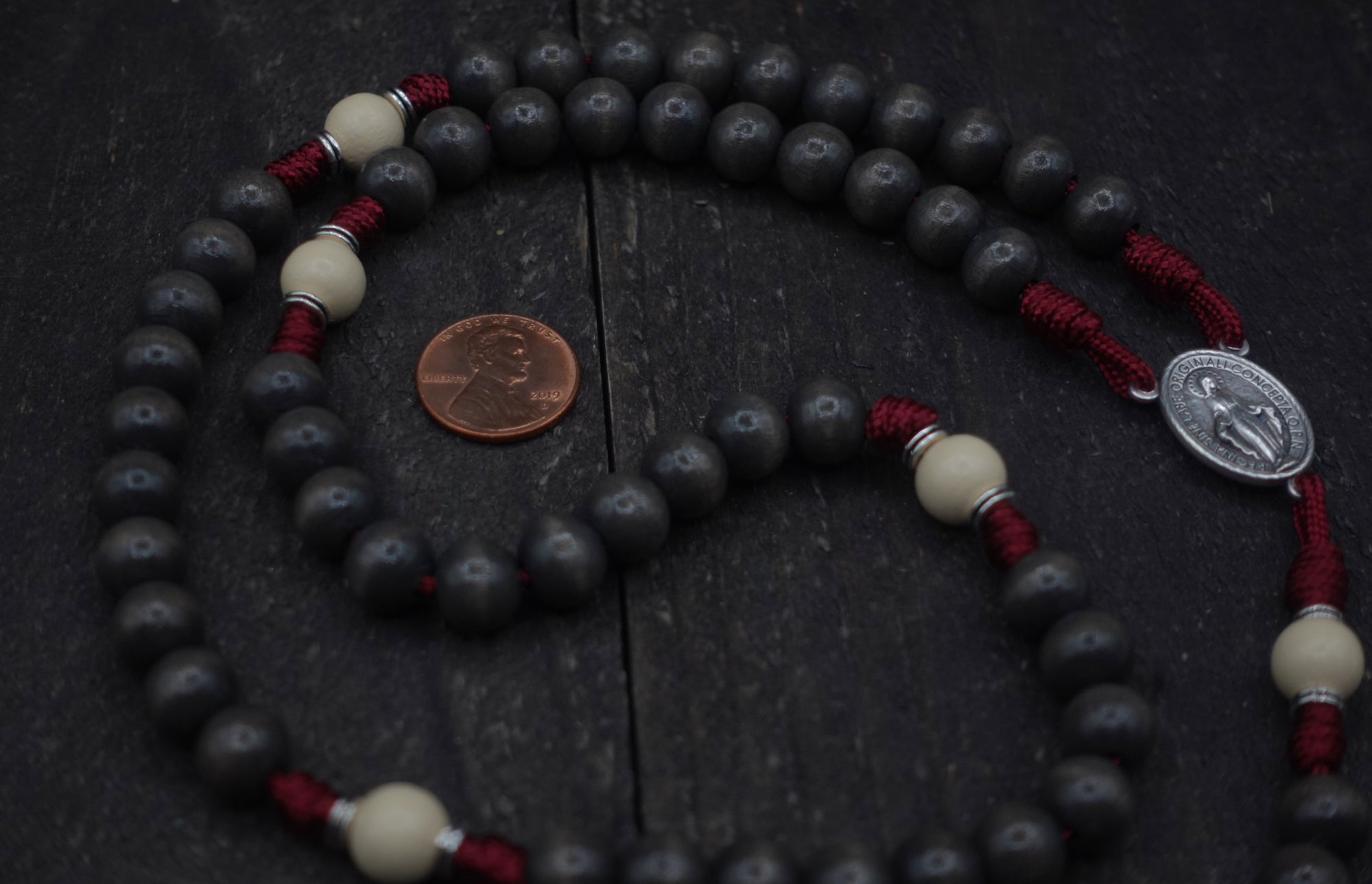 Close-up of charcoal and vintage white wooden beads on Pope Leo XIV rosary showing heirloom craftsmanship